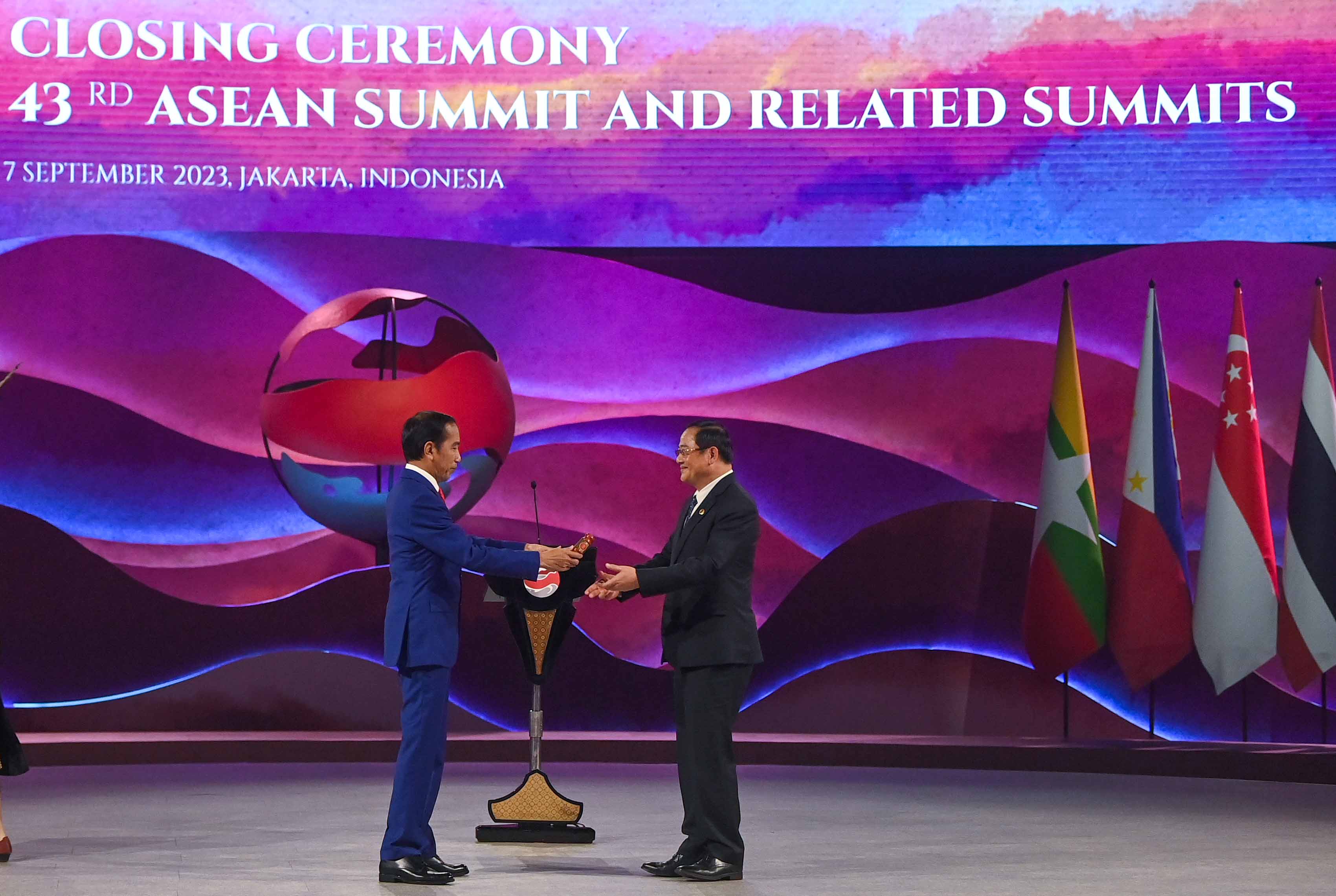 Presiden Joko Widodo (kiri) memberikan palu sidang sebagai simbol penyerahan Keketuaan ASEAN 2024 kepada Perdana Menteri Laos Sonexay Siphandone